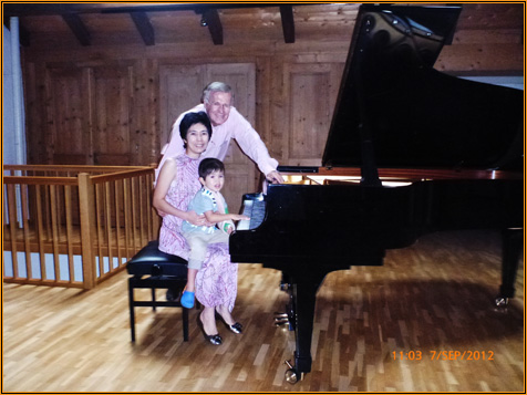 Yuuko Suzuki seated at the grand piano in the wood-panelled hall at Centre Phénix, photographed with two others after the recital